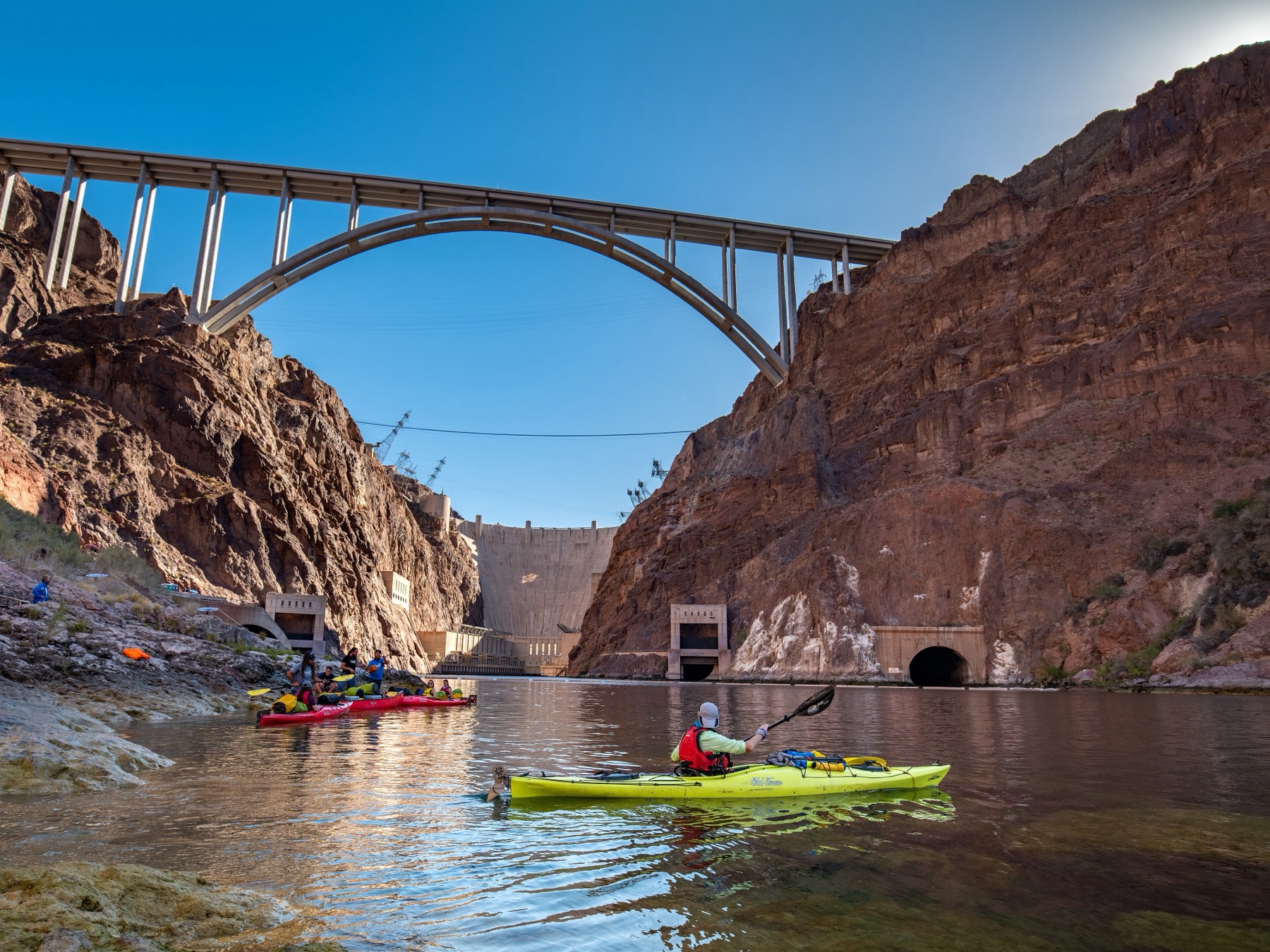 Kayakers on the Colorado River in a rock canyon below Hoover Dam