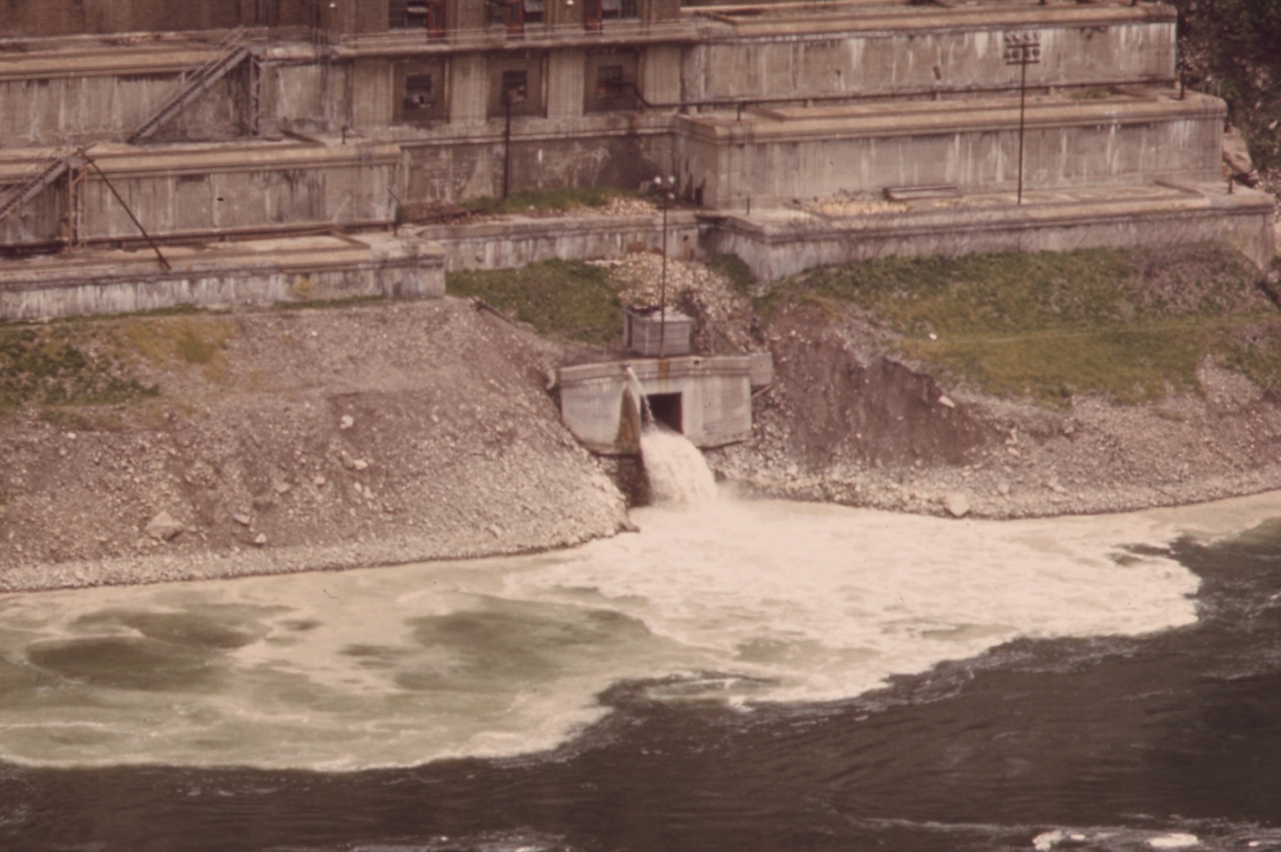 A sewage plant outfall pouring foaming discharge into the Niagara River in 1973